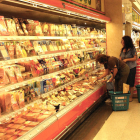Imagen de archivo de varios clientes haciendo la compra en la sección de cárnicos refrigerados.