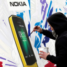Un artista pinta un cartell del Nokia 8110.