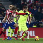 Leo Messi intenta avanzar con el balón ante la presión del francés Griezmann, en un partido en el que ninguno de los dos brilló especialmente.
