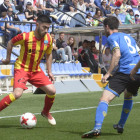 Un jugador del Lleida coduce el balón ante dos rivales.