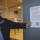 Santi Vergé muestra uno de los carteles que hay colgados en el pabellón donde juega el CN Tàrrega.