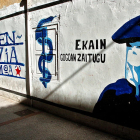 Mural que representa un encaputxat al costat de l’anagrama d’ETA.