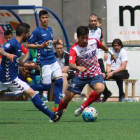 Genís porta una pilota davant l’oposició de dos jugadors rivals.