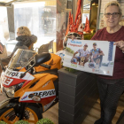 Elvira Colom, de la pastisseria Cal Colom, mostra un pòster al costat de la rèplica de la moto de Marc.