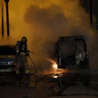 Un bomber a l'apagar les flames de la furgoneta que es va calcinar.
