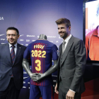 Bartomeu y Gerard Piqué flanquean la camiseta que explicita la renovación del central hasta 2022.