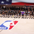 Los jugadores de los Lakers y los Clippers se arrodillan durante el himno nacional de EEUU.