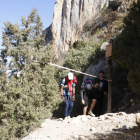 Excursionistes al passar ahir per sota d’una cinta per restringir el pas a una zona afectada per allaus a Mont-rebei.