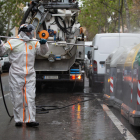 Un operari llança desinfectant sobre diversos contenidors, ahir, a Barcelona.