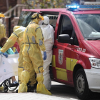Els bombers traslladen un dona a un hospital de campanya situat a Leganés, Madrid.
