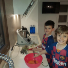 Jan, de siete años, y Kai, de tres, ayudando a preparar la cena ayer en su casa de Anglesola. 