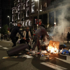 Individus incendiant cubells d’escombraries a la Gran Vía de Madrid, dissabte a la nit.