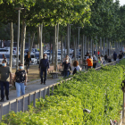 Paseantes por la calle Jaume II mientras los deportistas corren por la canalización