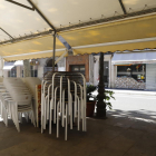 Sillas apiladas en la terraza de un bar cerrado en la Rambla Ferran de Lleida.
