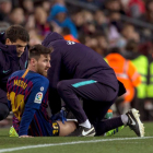 Leo Messi és atès a la banda durant el partit de dissabte contra el València.