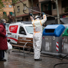 Un operario desinfectando un cubo de basura en Barcelona.