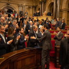 Torrent saluda al president Torra al término de la sesión, con la bancada independentista en pie, ayer.