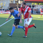 Un jugador de l’Alcarràs condueix la pilota davant la pressió d’un rival.