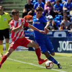 El centrocampista del Girona Pere Pons intenta arrebatar el balón a Olivera.