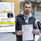 El afectado por la multa, al lado de su coche y con el documento de la admisión de la querella.