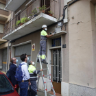 Un operari retira la placa franquista d’un bloc de Sant Jaume davant la mirada de Postius i Pueyo.