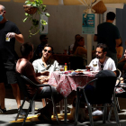 Diversos joves gaudeixen d’un vermut en una terrassa del Poble Sec a Barcelona.