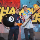 Marc y Àlex, con la bola número 8 de billar y el dardo, delante de una gran pancarta con la leyenda ‘Champion Brothers’.