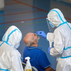 Sanitarios realizan una prueba de detección del virus a un hombre en Barcelona.