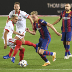 Frenkie de Jong disputa un balón con un rival sevillista.