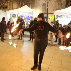 Espectáculo de fuego ayer en el mercado navideño de Mollerussa. A la derecha, una de las paradas con motivos navideños en el Mercat de Santa Llúcia de Lleida. 