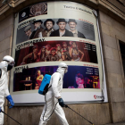 Operaris realitzen tasques de desinfecció als afores d’un teatre a Saragossa.