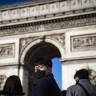 Varios turistas pasean frente al Arco del Triunfo de París.