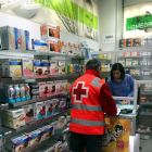 Un voluntari de Creu Roja recollint un medicament a una farmàcia de Lleida per portar-lo a un malalt.