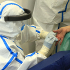 Un professional extreu una mostra de sang amb una punxada al dit d'una participant a l'estudi de seroprevalença del coronavirus a nivell estatal.
