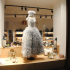 Una tienda del centro, con un vestido de papel en su escaparate. 