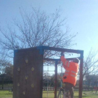 Un operario repara uno de los juegos de un parque infantil.