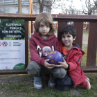 Dos niños pequeños con una pelota ayer en una plaza de Balàfia ante un cartel con la prohibición.