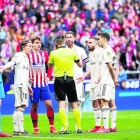 Jugadores del Real Madrid y del Atlético conversan con el leridano Estrada Fernández, ayer.