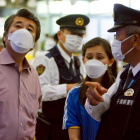 Ciudadanos y policías japoneses usan mascarillas para evitar contagiarse.