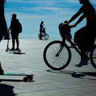Varias personas en bicicleta y patinetes en la playa de la Barceloneta durante la desescalada