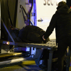 Uno de los españoles repatriados de la ciudad china de Wuhan por el riesgo de coronavirus carga maletas en un autobús antes de ser trasladado al hospital por la cuarentena el 31 de enero.