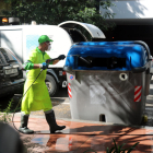 Un operario limpia un contenedor, ayer, junto a los Jardins de Montserrat, en Barcelona.