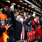 Un aficionado del Atlético, con mascarilla y guantes, celebra la clasificación del Atlético en Anfield.