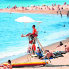 Varias personas disfrutando ayer del sol en una playa de Barcelona.