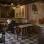 Una camarera desinfecta las sillas en un bar de Sevilla.