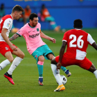 Leo Messi controla la pilota davant de Gumbau i Ibrahim Kebe, jugadors del Girona.