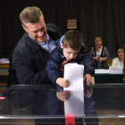 Un niño deposita el voto de su progenitor en una urna, ayer.