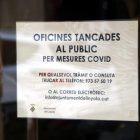 Un cartel informativo sobre la suspensión de la atención al público por el brote de covid-19 en la puerta del Ayuntamiento de Linyola.