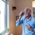 Un hombre asmático utiliza un inhalador.