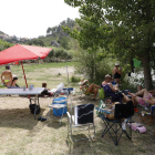 Taules de pícnic, gandules i para-sols a la ribera del riu Segre a Camarasa.